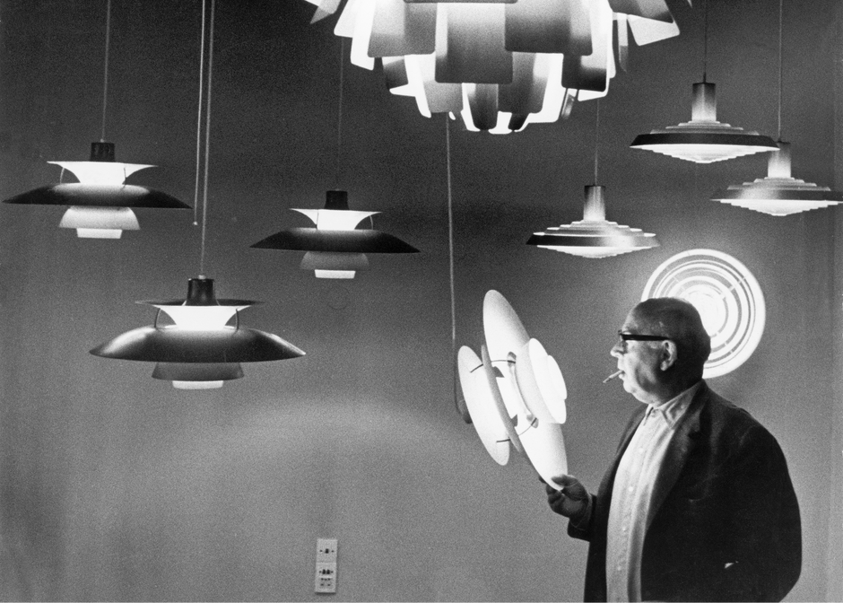 Designer Poul Henningsen looking at his design
